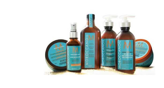 A range of Moroccanoil hair care products, including oil, lotion, and shampoo bottles.